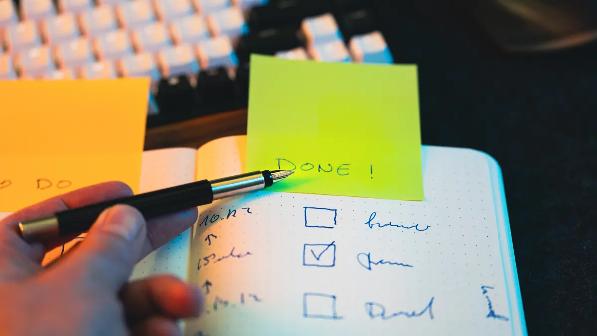 Checklist notebook with pen and sticky note