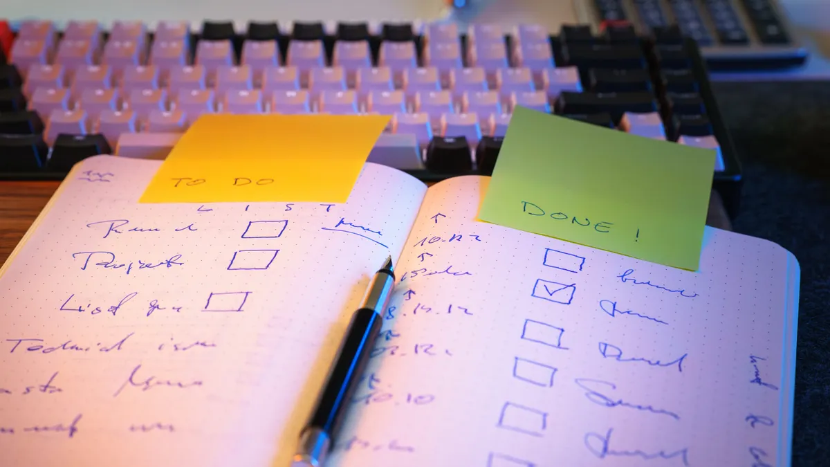Open notebook with handwritten checklist and sticky notes