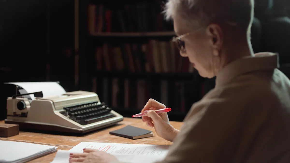 editor reading pages beside a typewriter
