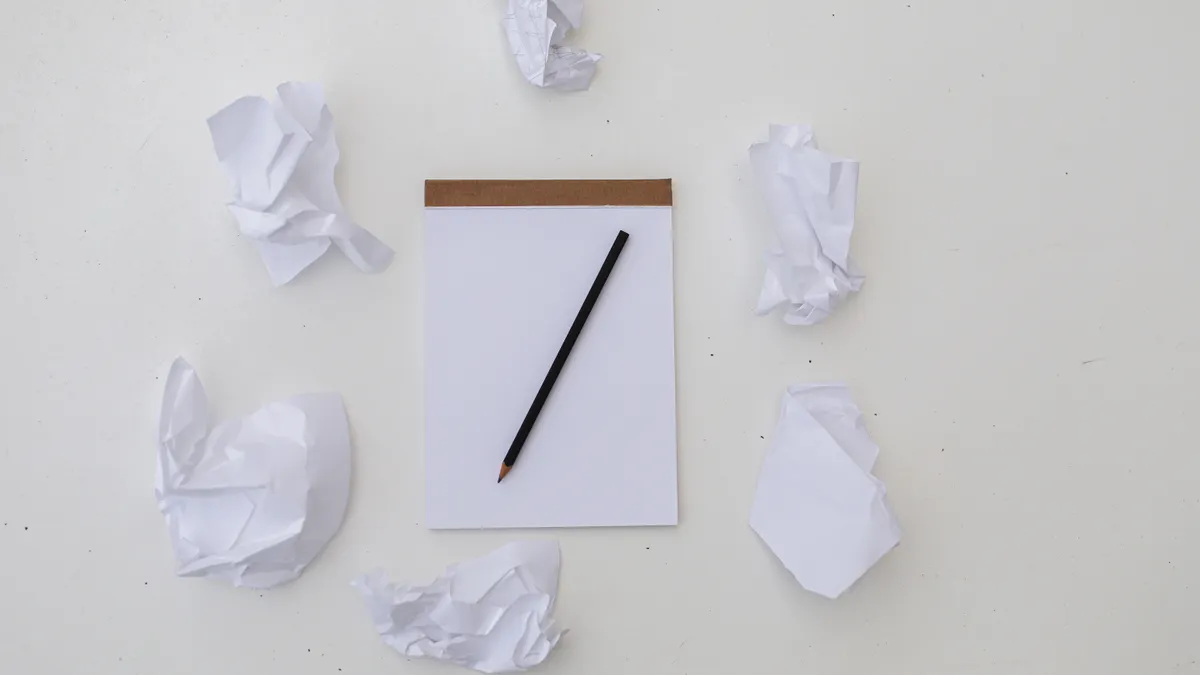 AI article writer vs AI content rewriter: which tool should you use for blog content blank page with pencil and crumpled paper