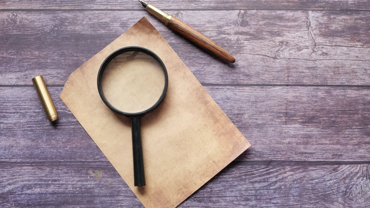 Magnifying glass with paper and pen